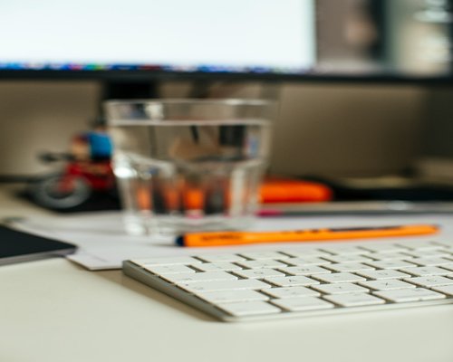organized work desk with water and natural light