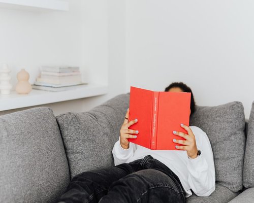 person reading a book in a comfortable room